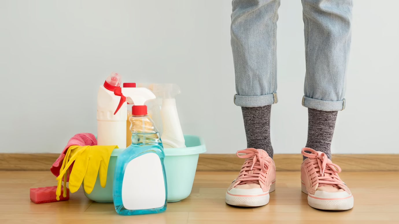 Front View on a standing person with cleaning solutions and gloves on the side