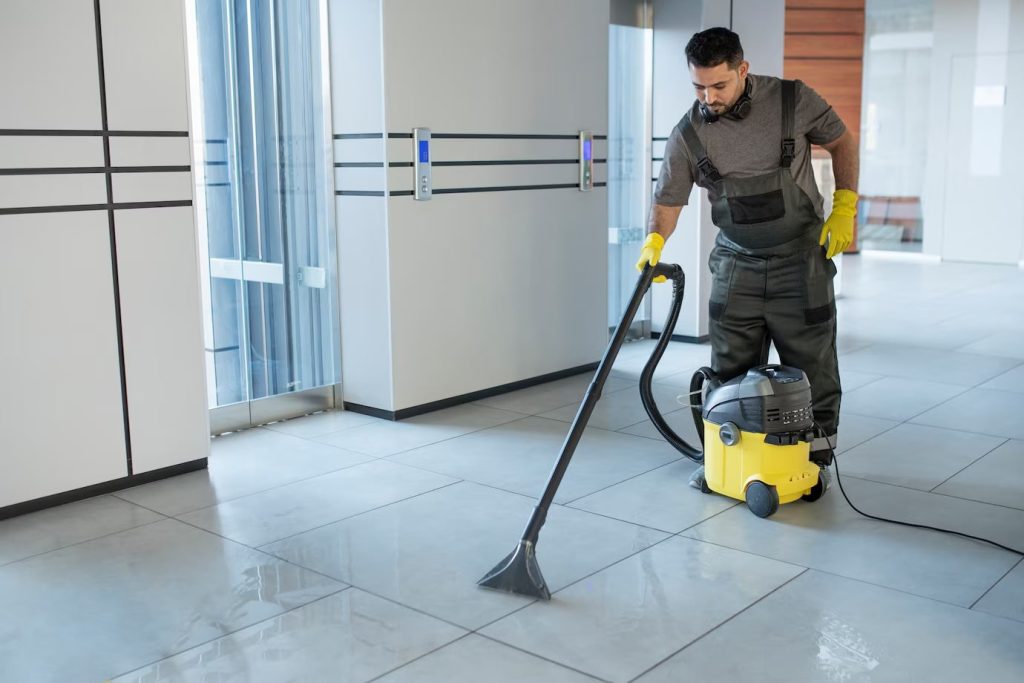 Full Shot of a Man Vacuuming Office Floor