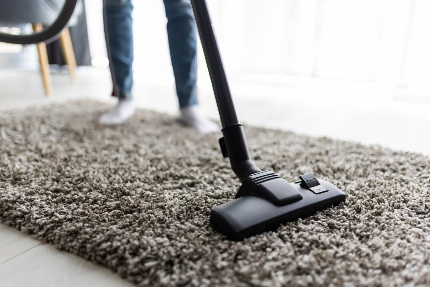 Man cleaning carpet with vacuum cleaner