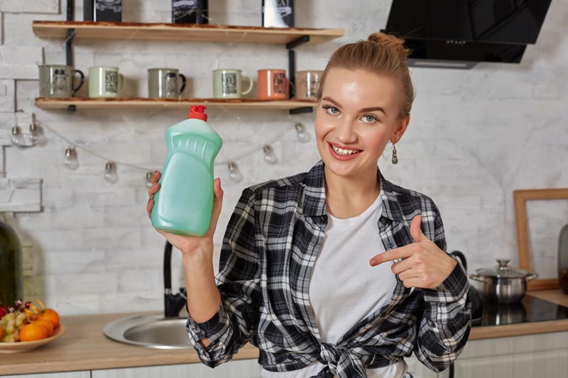 young woman smiling house wife in kitchen doing house cleaning